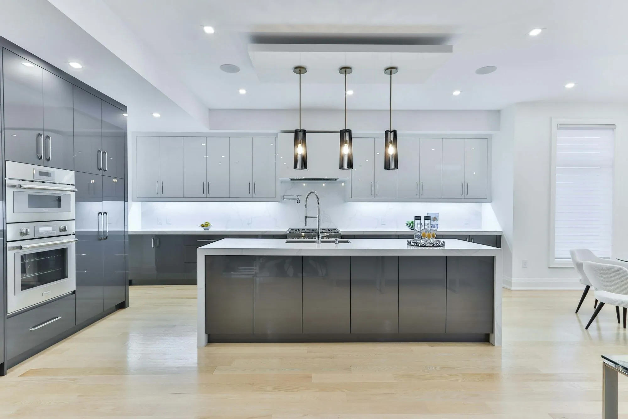 Renovated kitchen, grey cabinetry, white island, pendant lights